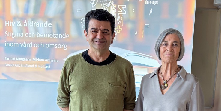 Två personer står framför en presentation om hiv och åldrande i ett klassrum.