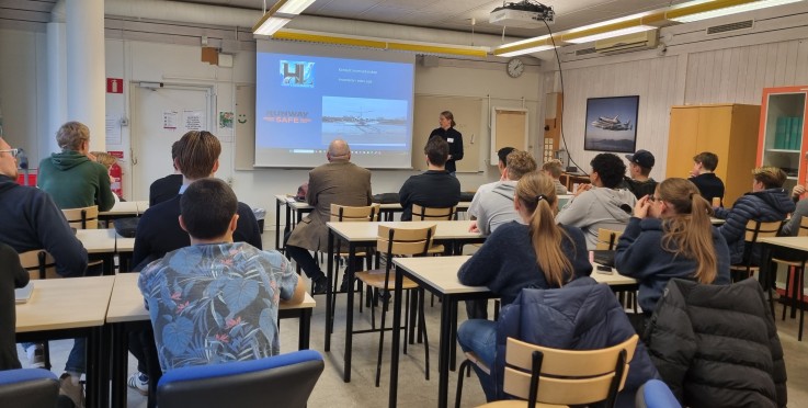 En grupp studenter sitter i ett klassrum och lyssnar på en presentation om flygsäkerhet.