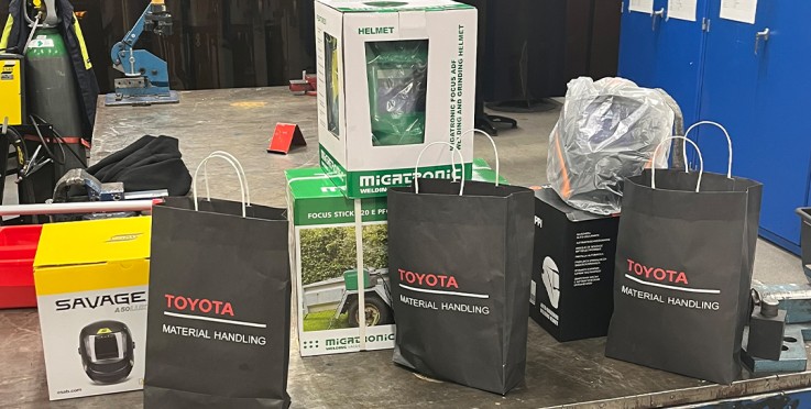 Ett bord i en verkstad med presentpåsar, hjälmar och verktyg.