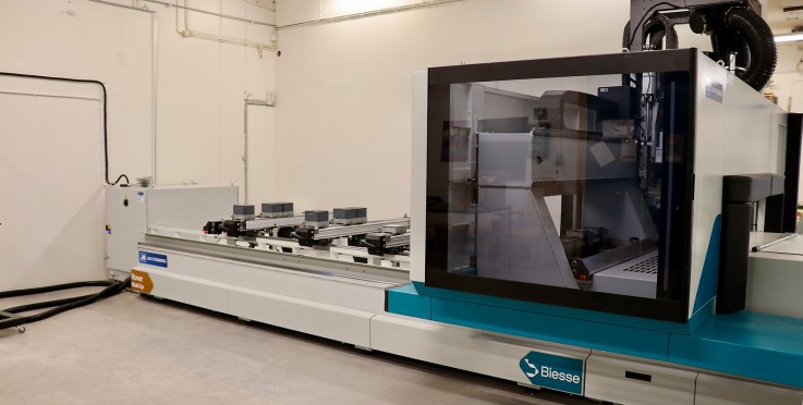 Stor CNC-maskin i ett ljust industrirum, maskinen är märkt med Biesse.