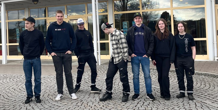 En grupp unga personer står framför en byggnad med skylten Väderstad.